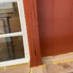 a window with a white frame next to a red wall