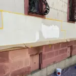 a building with a paint bucket and a metal grate